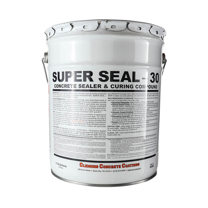 A white metal bucket of Clemmons Concrete Castings Super Seal 30 Concrete Sealer & Curing Compound, featuring a detailed black and red label with instructions and safety information.