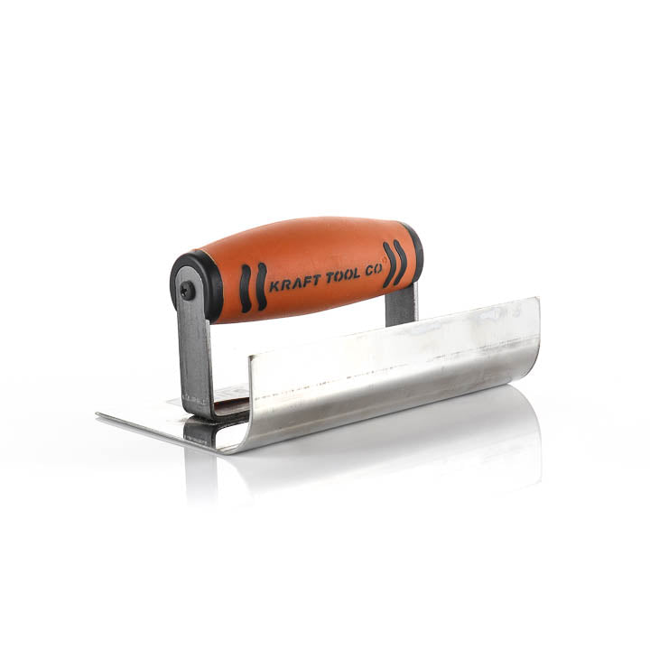 A metal trowel with a bright orange ergonomic handle and black grip details, branded 'KRAFT TOOL CO.', shown on a clean white background with a soft reflection.