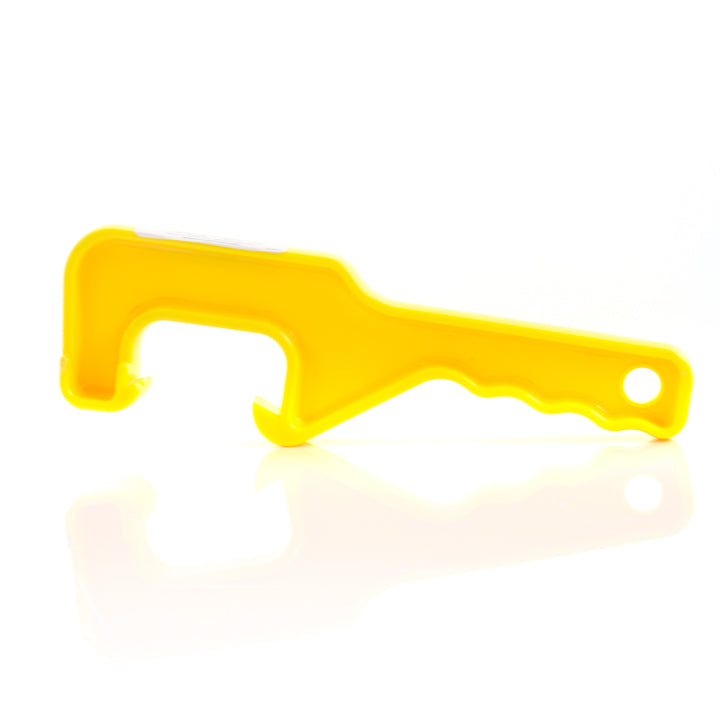 A yellow Kraft Tool plastic lid claw resting on a white surface, shown from the side with its curved hook and textured handle.