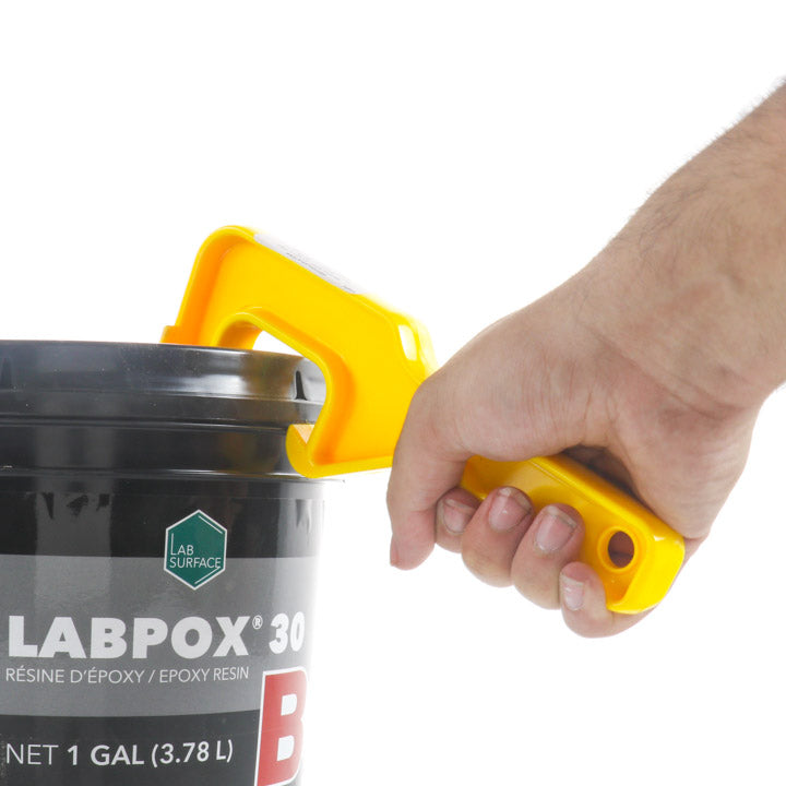 A hand using a yellow Kraft Tool plastic lid claw to pry open the lid of a Labpox 30 epoxy resin container.