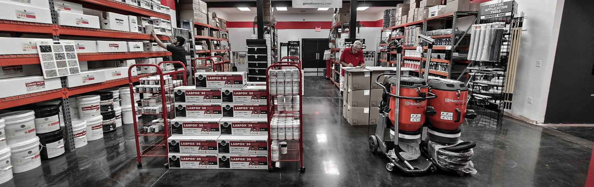 A warehouse showroom with shelves stocked with products, red carts holding boxes of LABPOX 30, and industrial equipment in the foreground.
